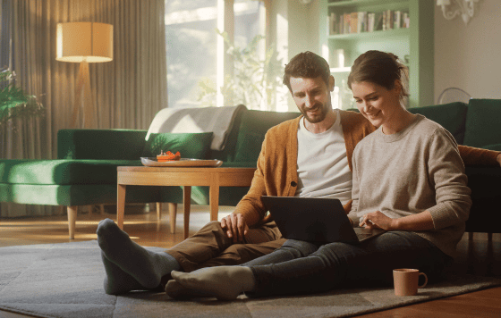 Couple relaxing at home with laptop