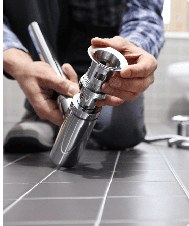 Plumber installing sink drain assembly chrome pipe
